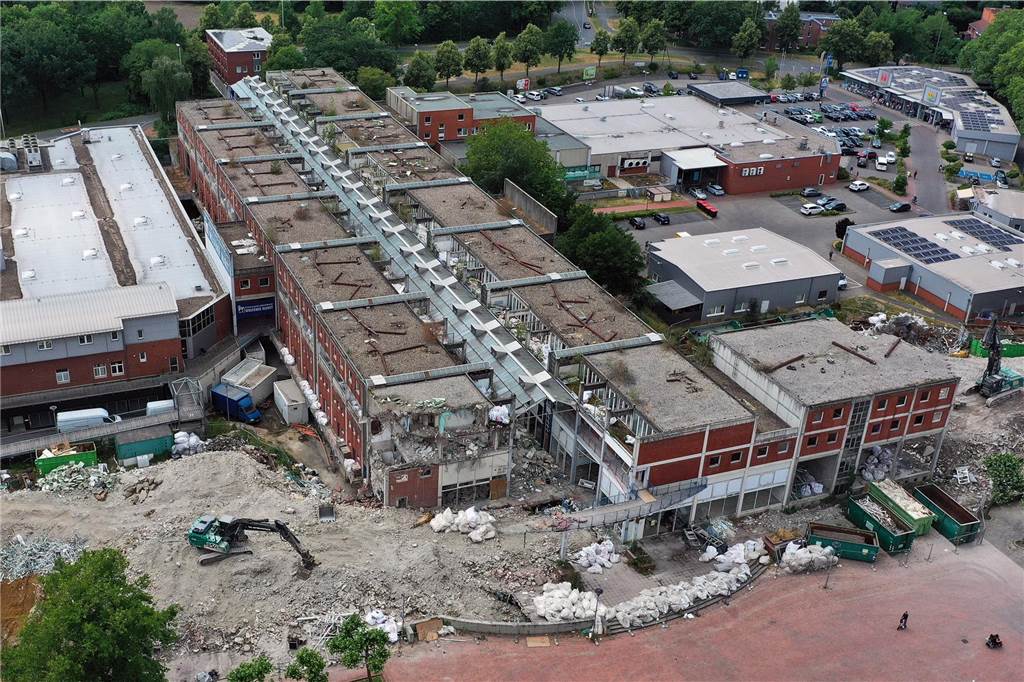 Der erste Flügel, vom Marktplatz aus gesehen links, ist bereits komplett abgerissen. Hier werden nur noch die Baustoffe getrennt. Auf der anderen Seite zerlegen die Bagger die einzelnen Wohnungen, Stockwerk für Stockwerk. Auch hier nähert man sich rasant der mittleren ehemaligen Einkaufsmeile.