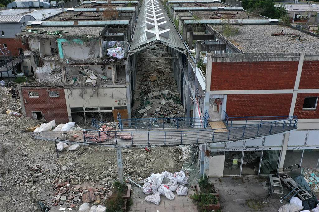 Der erste Flügel, vom Marktplatz aus gesehen links, ist bereits komplett abgerissen. Hier werden nur noch die Baustoffe getrennt. Auf der anderen Seite zerlegen die Bagger die einzelnen Wohnungen, Stockwerk für Stockwerk. Auch hier nähert man sich rasant der mittleren ehemaligen Einkaufsmeile.
