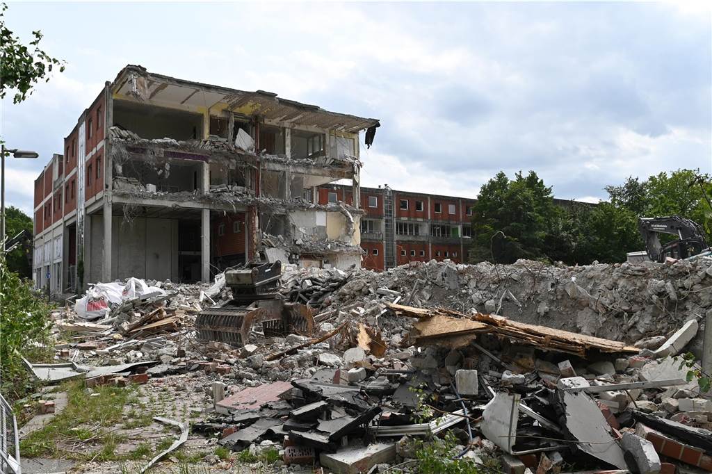 Der erste Flügel, vom Marktplatz aus gesehen links, ist bereits komplett abgerissen. Hier werden nur noch die Baustoffe getrennt. Auf der anderen Seite zerlegen die Bagger die einzelnen Wohnungen, Stockwerk für Stockwerk. Auch hier nähert man sich rasant der mittleren ehemaligen Einkaufsmeile.