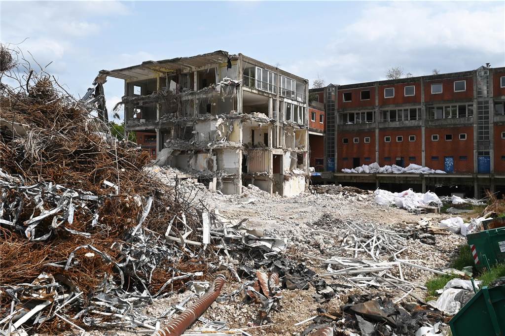 Der erste Flügel, vom Marktplatz aus gesehen links, ist bereits komplett abgerissen. Hier werden nur noch die Baustoffe getrennt. Auf der anderen Seite zerlegen die Bagger die einzelnen Wohnungen, Stockwerk für Stockwerk. Auch hier nähert man sich rasant der mittleren ehemaligen Einkaufsmeile.