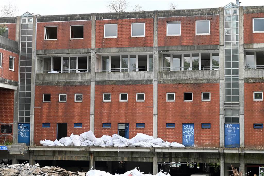 Der erste Flügel, vom Marktplatz aus gesehen links, ist bereits komplett abgerissen. Hier werden nur noch die Baustoffe getrennt. Auf der anderen Seite zerlegen die Bagger die einzelnen Wohnungen, Stockwerk für Stockwerk. Auch hier nähert man sich rasant der mittleren ehemaligen Einkaufsmeile.