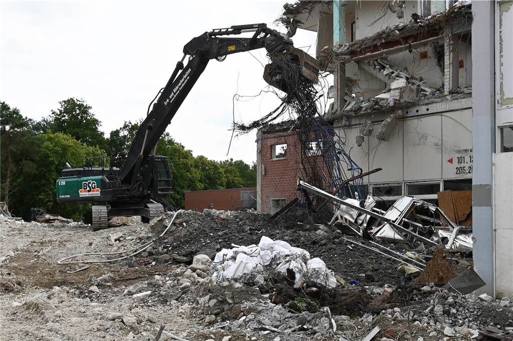 Der erste Flügel, vom Marktplatz aus gesehen links, ist bereits komplett abgerissen. Hier werden nur noch die Baustoffe getrennt. Auf der anderen Seite zerlegen die Bagger die einzelnen Wohnungen, Stockwerk für Stockwerk. Auch hier nähert man sich rasant der mittleren ehemaligen Einkaufsmeile.
