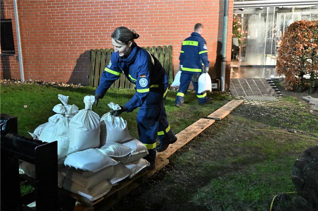 Hochwasser in Haltern: THW und DLRG im Dauereinsatz THW Helfer schleppen Sandsäcke.