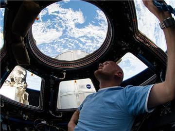 Der ESA-Astronaut Alexander Gerst blickt während seines Fluges mit der Internationalen Raumstation durch ein Fenster in der Kuppel auf die Erde. Foto: Nasa/dpa