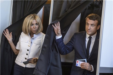 Der französische Staatspräsident Emmanuel Macron (r) und seine Ehefrau Brigitte (l) nach der Stimmabgabe.