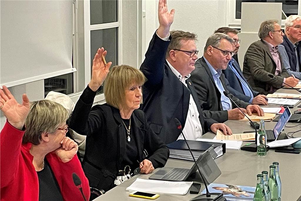Mitglieder des Gemeinderates Ascheberg heben die Hand zur Abstimmung.