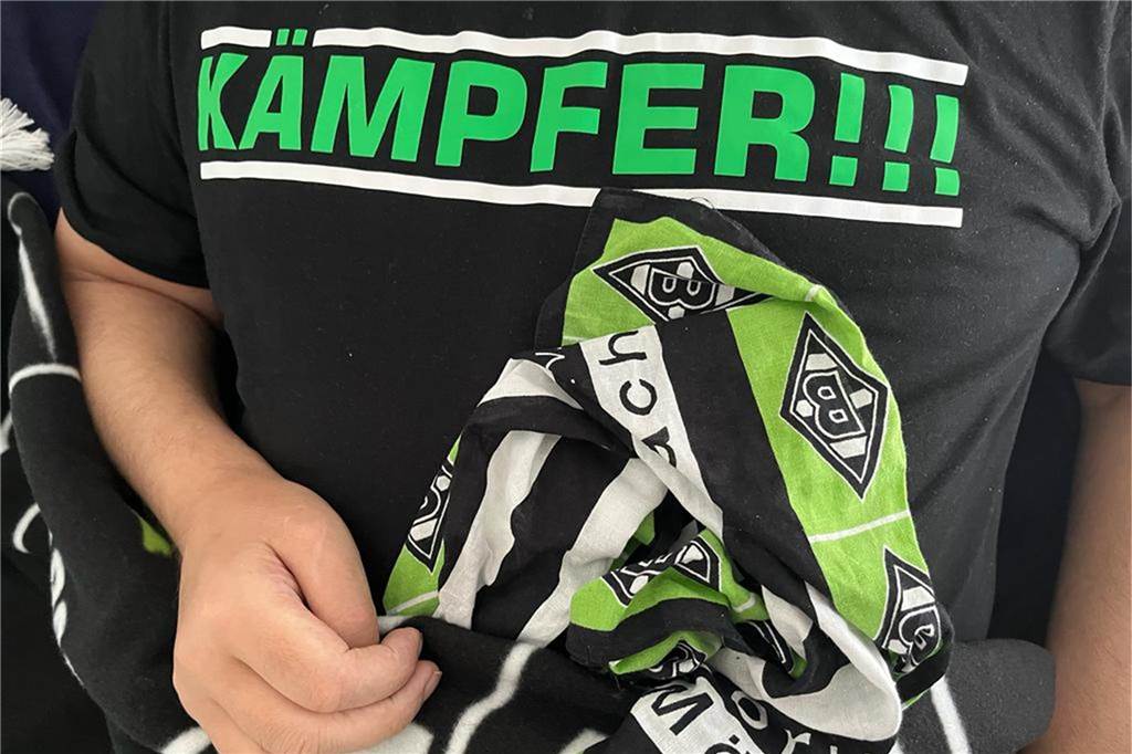 Der glühende Fan von Borussia Mönchengladbach trägt bei unserem Besuch ein T-Shirt, das ihm ein Freund geschenkt hat. Es symbolisiert das Motto der Familie: Sie kämpfen für und mit ihrem Vater und Ehemann.