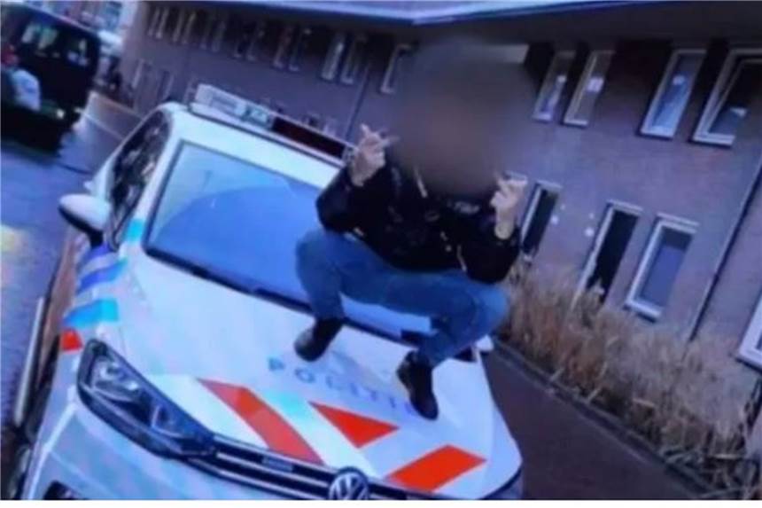 Mit „Stinkefinger“ auf Motorhaube von Polizeiauto: Strafe folgt auf dem Fuß Der „harte“ Junge in Enschede. Sein Foto musste er mit einer Fahrt zum Polizeirevier bezahlen.