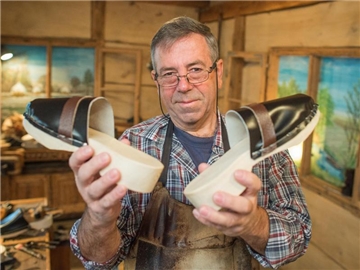 Der Holzpantoffelmacher Manfred Karolczak aus dem brandenburgischen Burg ist stolz auf seine handgefertigten Schuhe. Foto: Patrick Pleul