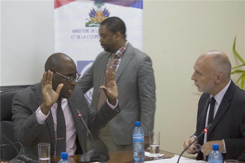 Haiti entzieht Oxfam Großbritannien die Arbeitserlaubnis Der Internationale Regionaldirektor von Oxfam für Lateinamerika, Ticehurst, spricht mit Haitis Minister für Planung und Äußere Kooperation, Fleurant. Foto: Dieu Nalio Chery/AP