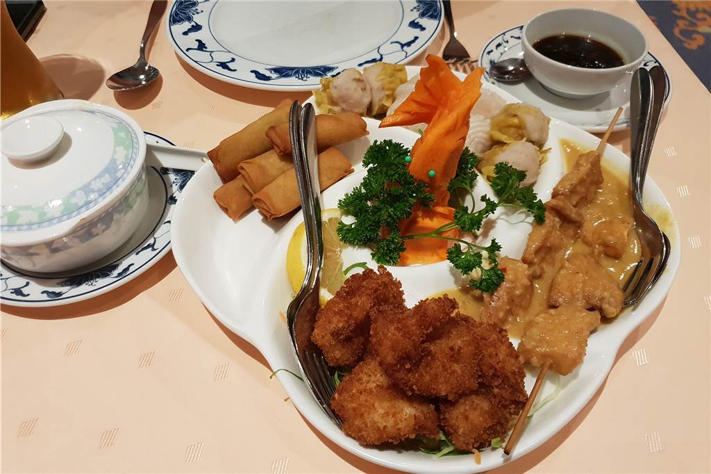 Das China-Restaurant Jade überzeugt mit knuspriger Ente, Erdnuss-Soßen und gebackenem Eis Der „Jade“-Spezialitäten Vorspeisenteller mit gedämpften Dim-Sum, Saté-Spießen, gebackenen Garnelen und Mini-Frühlingsrollen. Dazu gibt es süß-saure- und Erdnuss-Soße. Zusätzlich einen Soja-Dip für die Dim-Sum.