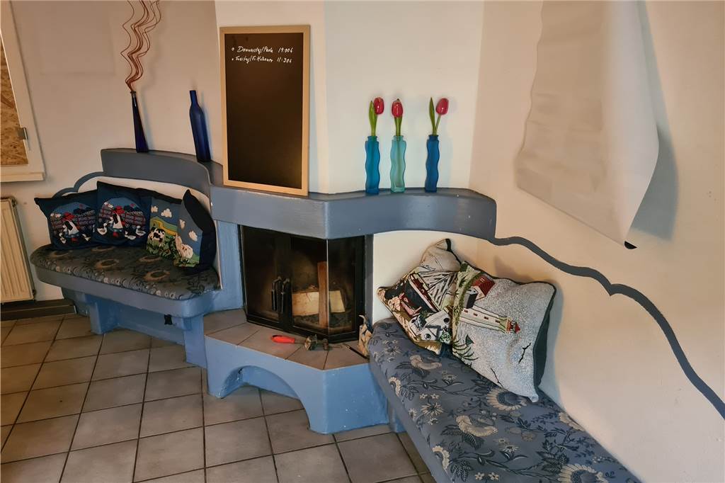 Der Kamin mit brennenden Holzscheiten spendet zusätzlich zur Gasheizung Wärme.