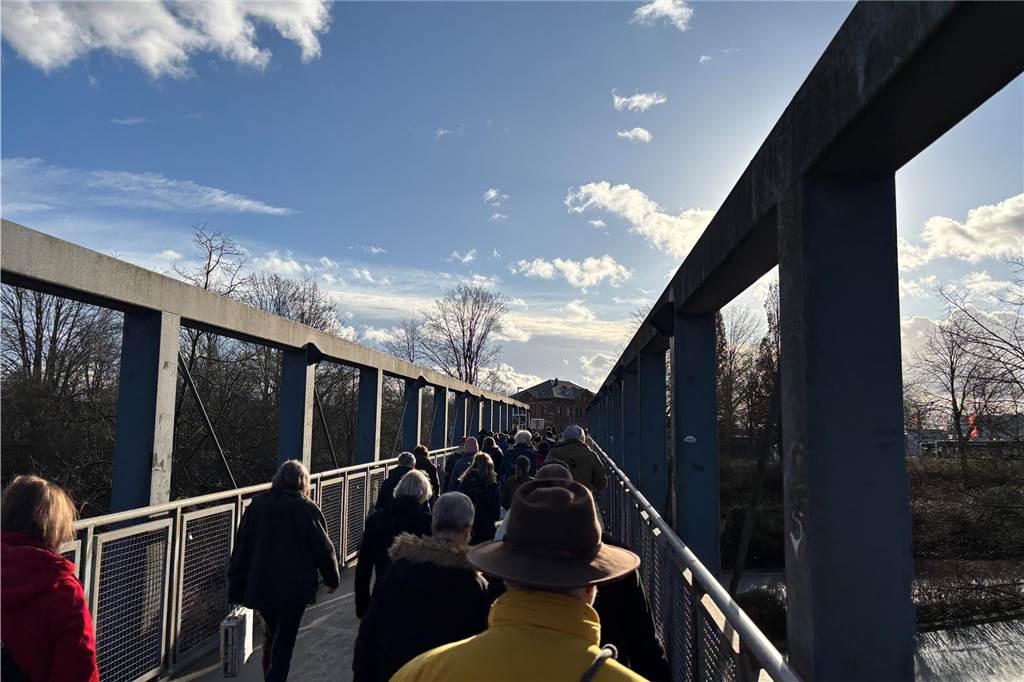 Teilnehmer laufen über eine Brücke. Das Bild stellt das Ende des Marsches dar und wurde von oben fotografiert. 