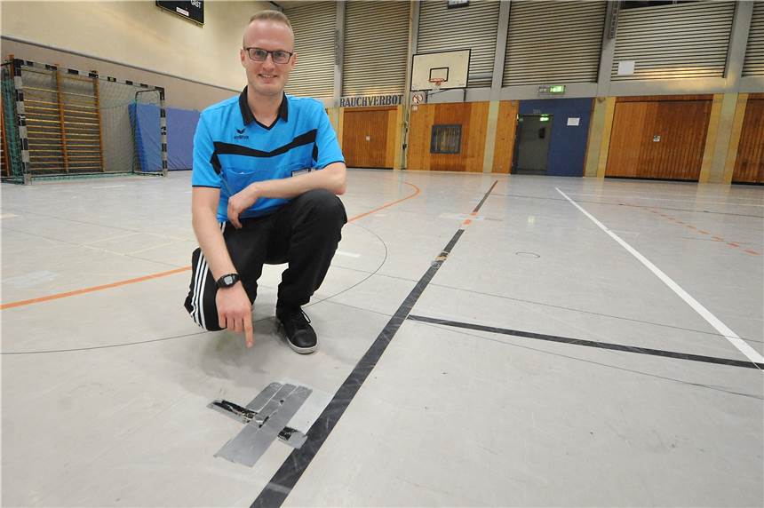 Ein Teil der ASG-Sporthalle ist wegen Beschädigungen gesperrt Der Korfball-Schiedsrichter Jan Weber-Winkels zeigt auf eine beschädigte Stelle des Hallenbodens.