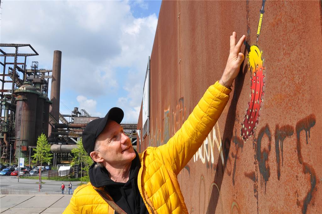 Auf dieses Graffito ist Dortmunds Impfzentrum mächtig stolz Der Künstler und sein Werk: Thomas Baumgärtel prüft, ob die Farbe seiner Impfbanane am Dortmunder Impfzentrum auf Phoenix-West schon trocken ist.