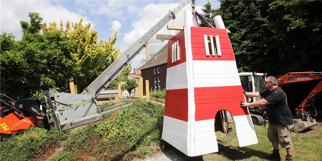 Kids sind stolz: Leuchtturm strahlt nun im Garten ihrer Kita St. Marien Der Leuchtturm schwebt am Haken eines Radladers in den Kita-Garten. Mike Oberhäuser sichert das neue Spielgerät.