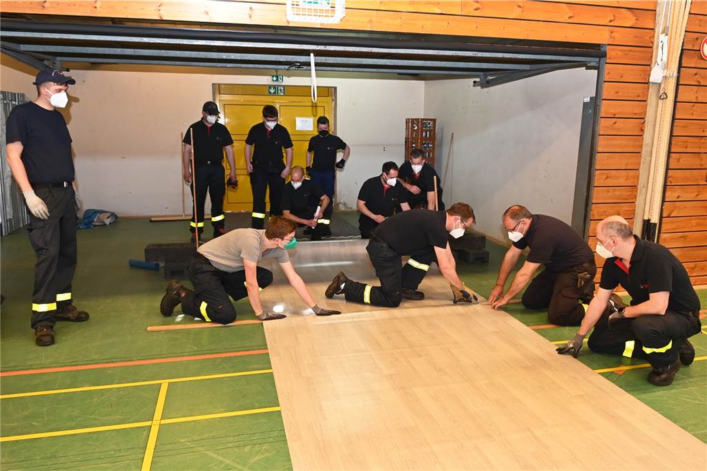 Kriegsflüchtlinge aus der Ukraine: Wer lebt wo in Dorsten? Feuerwehrleute verlegen neuen Boden in der Sporthalle der alten Josefschule