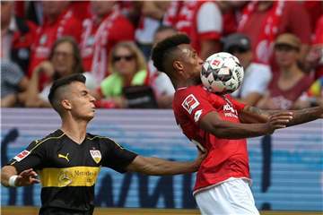 Der Mainzer Jean-Philippe Gbamin (r) schirmt den Ball gegen den Stuttgarter Erik Thommy ab. Foto: Thomas Frey