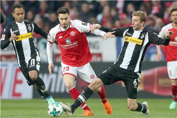 Der Mainzer Suat Serdar (m) und die Gladbacher Raffael (l) und Christoph Kramer kämpfen um den Ball. Foto: Thomas Frey