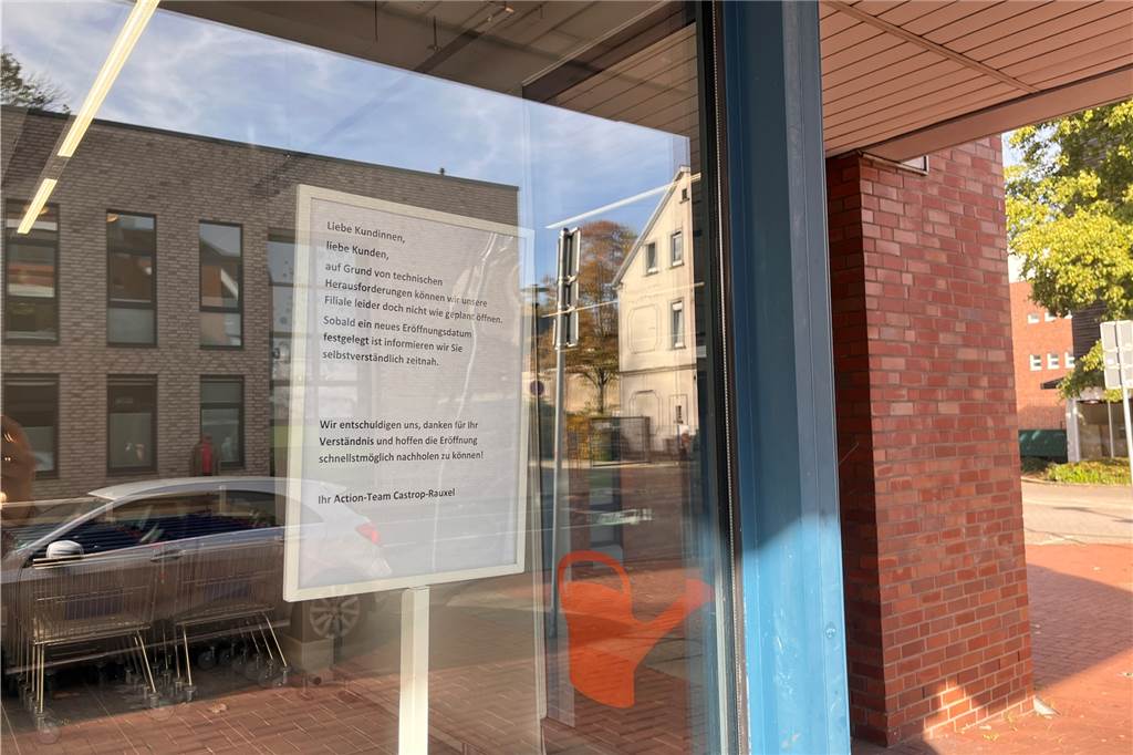 Trotz Absage am Vortag: Zahlreiche Kunden warten vor Action-Markt Schild im Schaufenster des Castroper Action-Marktes informiert die Kunden über die verschobene Eröffnung.