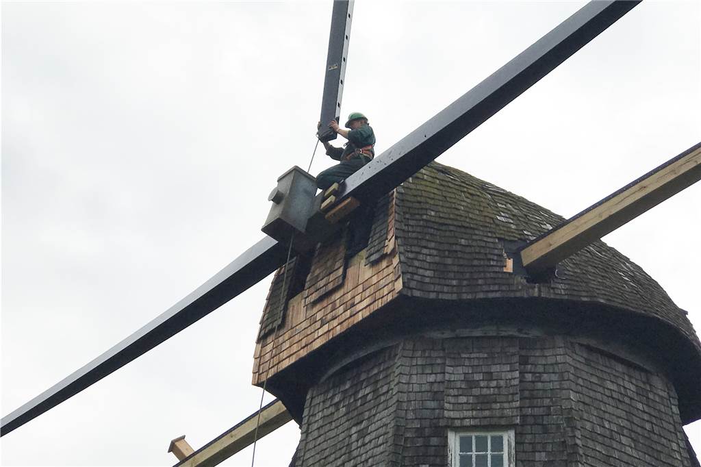 Tonnenschweres Drehkreuz am Haken: Quantwicker Mühle bekommt Flügel Der Mitarbeiter einer niederländischen Mühlenbaufirma passte das Drehkreuz ein.