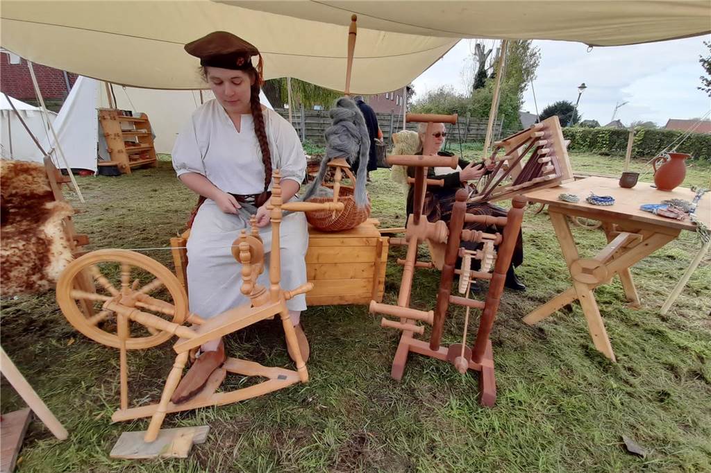 Volles Programm in Oeding: BulliBurg, Mittelaltermarkt und mehr Eine Frau sitzt auf einer Rasenfläche an einem Spinnrad. Sie ist Teilnehmerin des Mittelaltermarktes in Oeding.