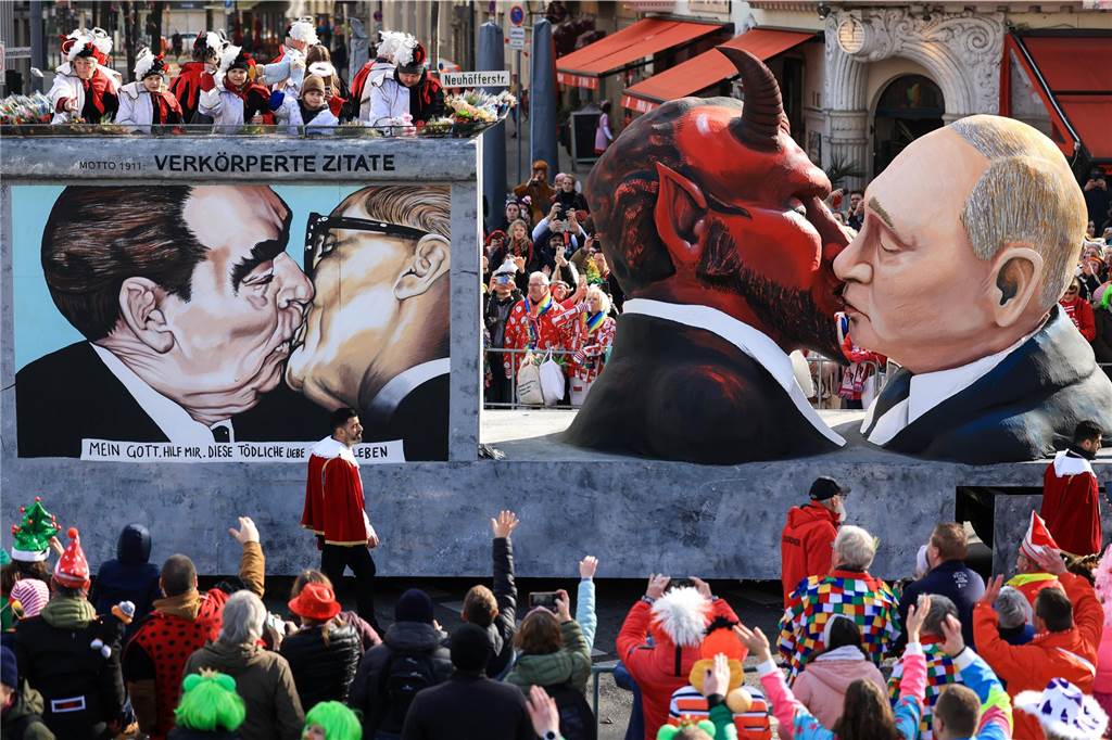 Karneval 2023 in NRW Der Mottowagen "Verkörperte Zitate", dem Motto der Session von 1911, mit einer Darstellung des russischen Präsidenten Putin der den Teufel küsst, fährt im Festumzug mit.