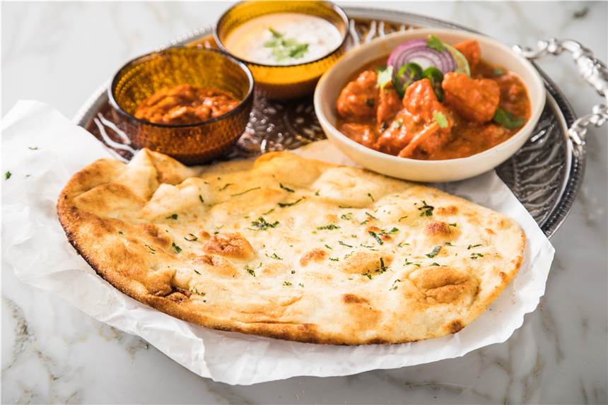 Fladenbrot selbst backen: Mit diesen Tipps halten Sie das Pita, Yufka und Co. schön flach Der Naan-Fladen kann zu Chicken Tikka Masala, Gemüse-Raita und Mixed Pickles aufgerupft werden.
