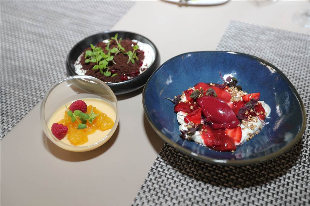 Der Nachtisch: Cheesecake-Creme, marinierte Erdbeeren, Beerensorbet; Schokoladen-Pumpernickel-Erde mit Kirsche und Rumgel; Gesalzene Karamell-Panna Cotta mit Birnen-Kompott.