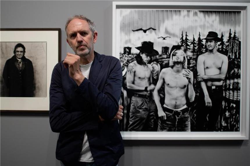 Anton Corbijn: „Musik war das größte Ding für mich“ Der niederländische Fotograf Anton Corbijn im Bucerius Kunst Forum vor seinen Fotografien der Band Nirvana (1993, r) und dem Country-Star Johnny Cash (1993). Foto: Daniel Reinhardt