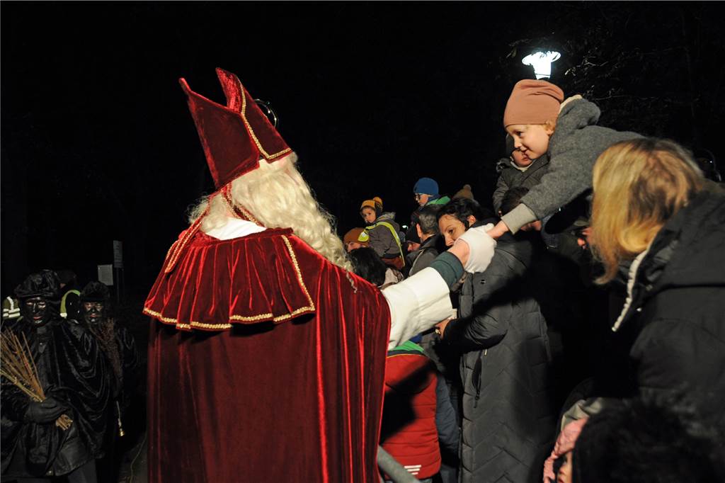 Der Nikolaus begrüßt die Kinder am Zaun