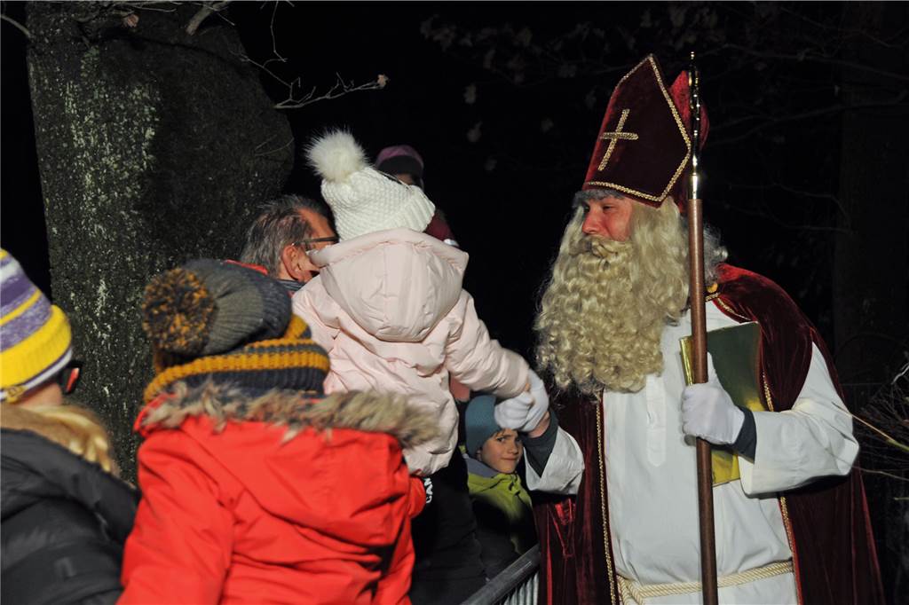 Der Nikolaus begrüßt die Kinder am Zaun