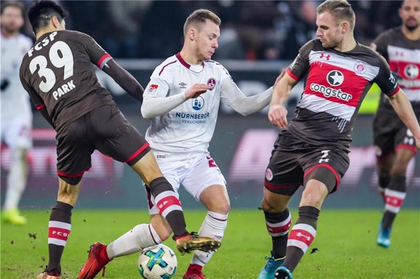 Nürnberg verpasst gegen St. Pauli Sprung an Tabellenspitze Der Nürnberger Federico Palacios Martinez (M) wird von St. Paulis Bernd Nehrig (l) und Yi-Young Park in die Zange genommen. Foto: Axel Heimken