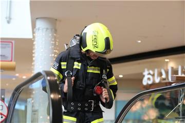 Der österreichische Extremsportler und Feuerwehrmann Andreas Michalitz in Montur auf einer Rolltreppe. Foto: Presseteam d. Feuerwehr Wr. Neustadt