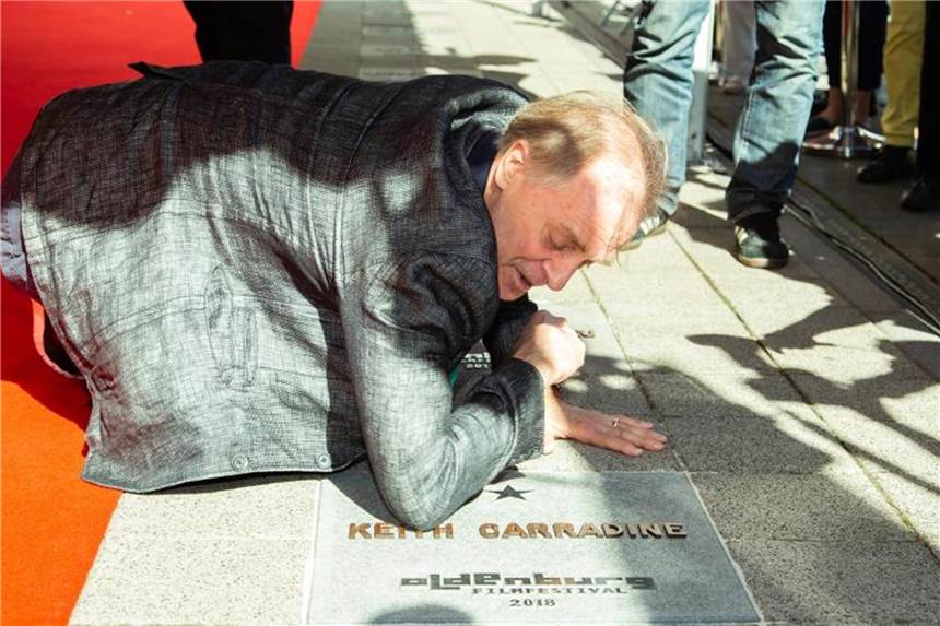 Der Oscarpreisträger Keith Carradine poliert seinen Stern mit dem Ärmel. Foto: Mohssen Assanimoghaddam