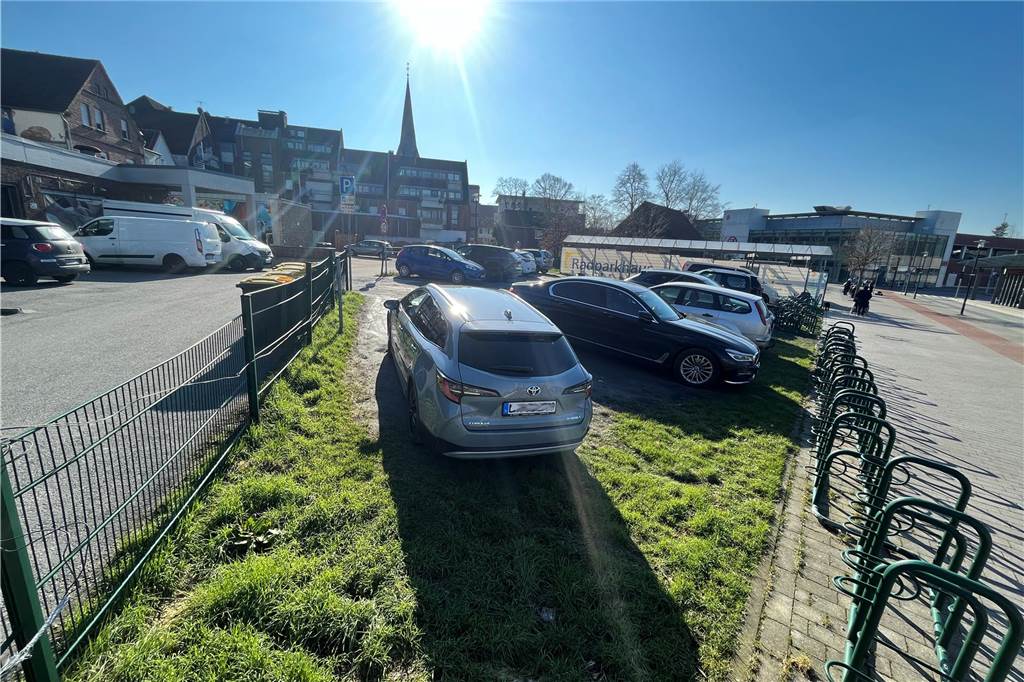 Bürger sollen bei Planungen für Hühnerhof mitwirken - auch per Smartphone Autos stehen auf dem Parkplatz am Grundstücksrand.