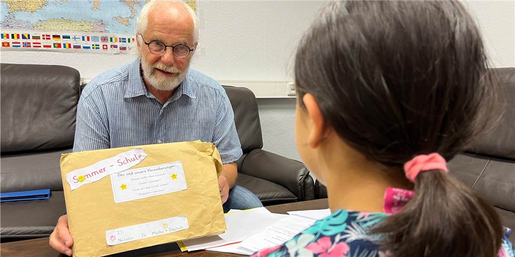 Der pensionierte Lehrer Bernd Höhne unterrichtet im Rahmen der Sommerschule auch die achtjährige Nazalin. Die Lehrerin der Grundschülerin hat einen liebevoll gestalteten Umschlag mit Arbeitsblättern gefüllt.