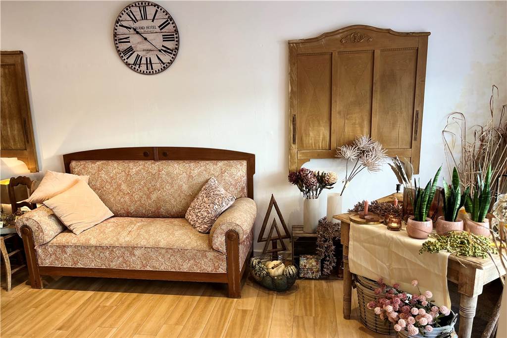Pop-up-Store: Blumen Stricker schnuppert endlich Mittelstraßen-Luft Eine Couch steht in einem Raum mit vielen Pflanzen.