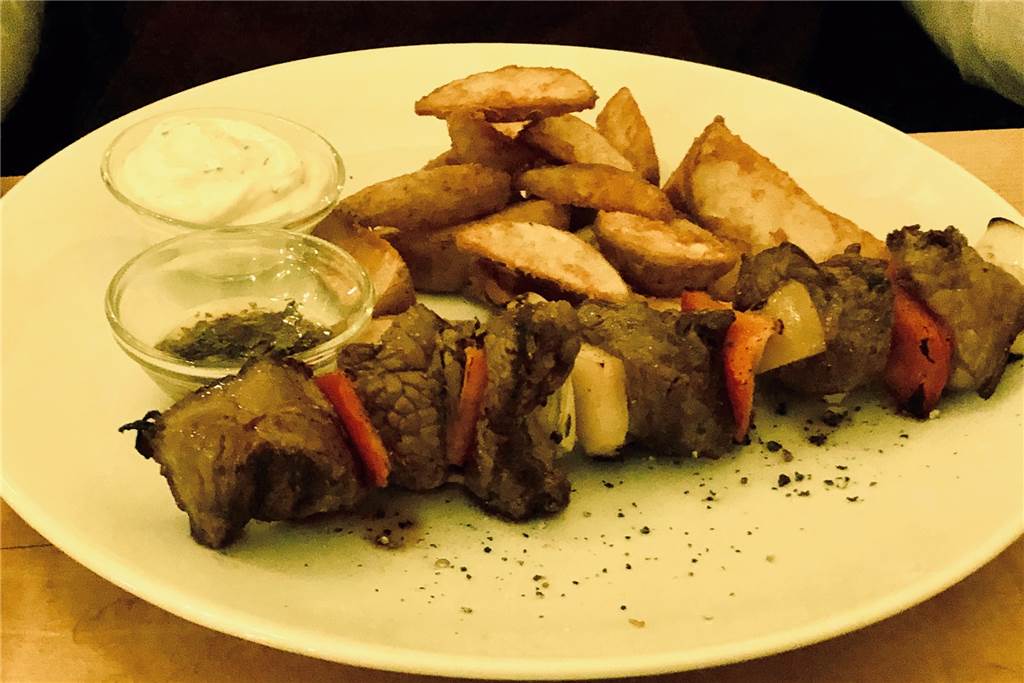 Der Rindfleischspieß kommt mit Paprika und Zwiebeln.