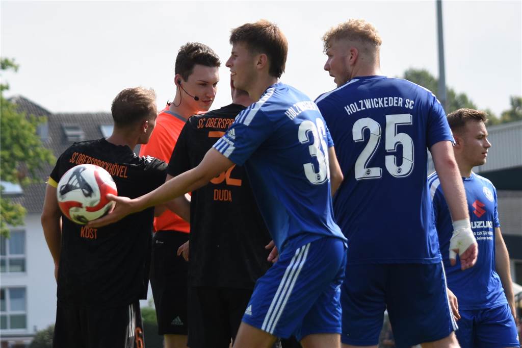 Holzwickeder SC ist nach Pires-Jokertor Spitzenreiter Der SC Obersprockhövel diskutiert nach 40 Minuten mit Schiedsrichter Jonas Fischbach. Der gefoulte Connor McLeod reicht unterdessen den Ball weiter zu Elfmeterschütze Andreas Spais.