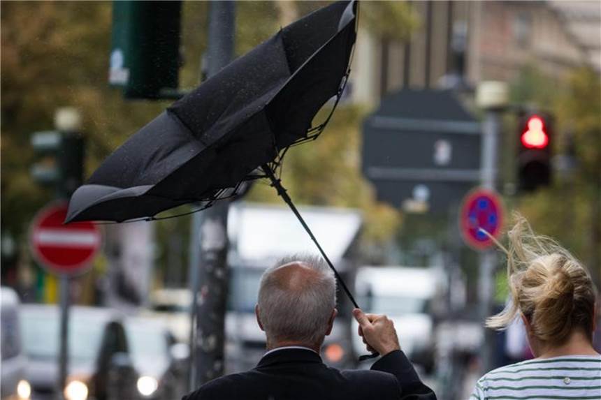 Tief „Fabienne“ fegt den Sommer weg Der Schirm eines Passanten klappt in Frankfurt am Main bei Sturm und Regen um. Foto: Frank Rumpenhorst