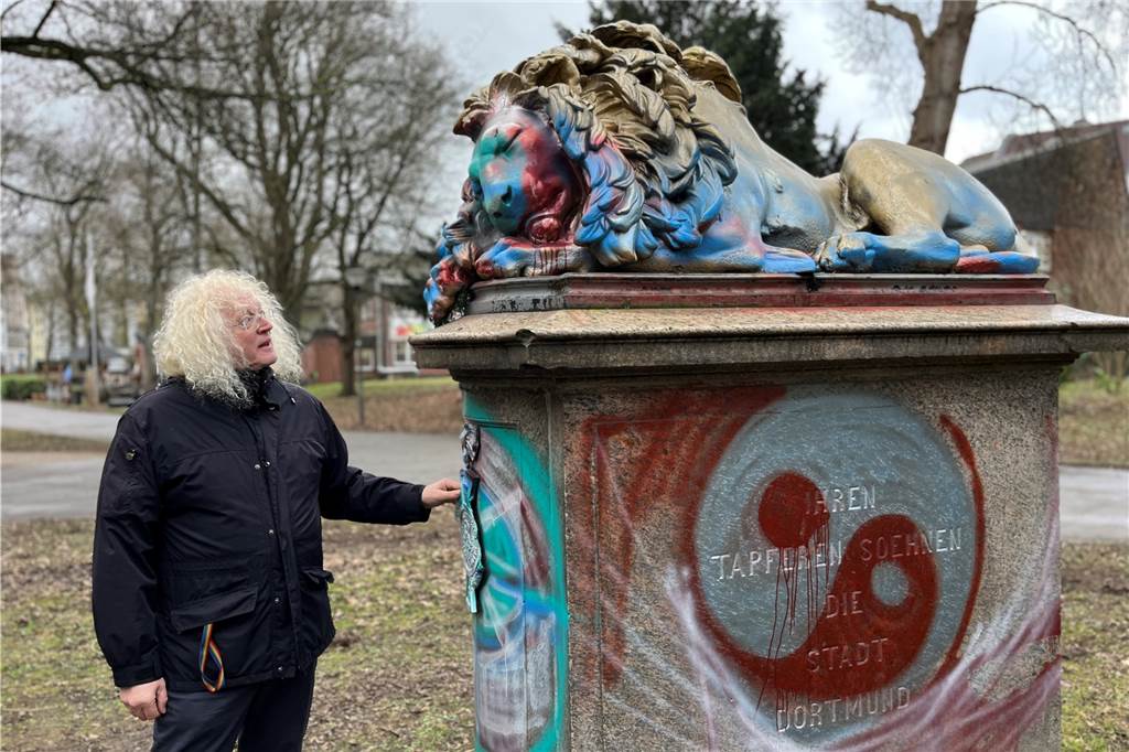 Der schlafende Löwe ist komplett mit Farbe beschmiert worden. Bezirksbürgermeister Friedrich Fuß schaut sich die Schäden an.