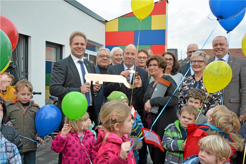 Der Schlüssel wird von Stephan Patz, Geschäftsführer der Gesellschaft für Bauen und Wohnen, und Oberbürgermeister Bernd Tischler symbolisch an die Leitung des Montessori-Kinderhauses, Andrea Sareyka, übergeben.