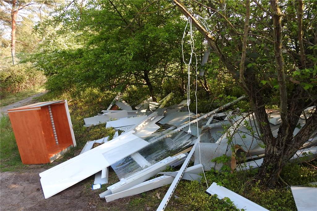 Illegal entsorgt: Sperrmüll am Silbersee II führt direkt zum Täter Ein Haufen Schrankteile liegt auf einer Grünfläche. Ein Stromkabel ist um einen Ast gewickelt.