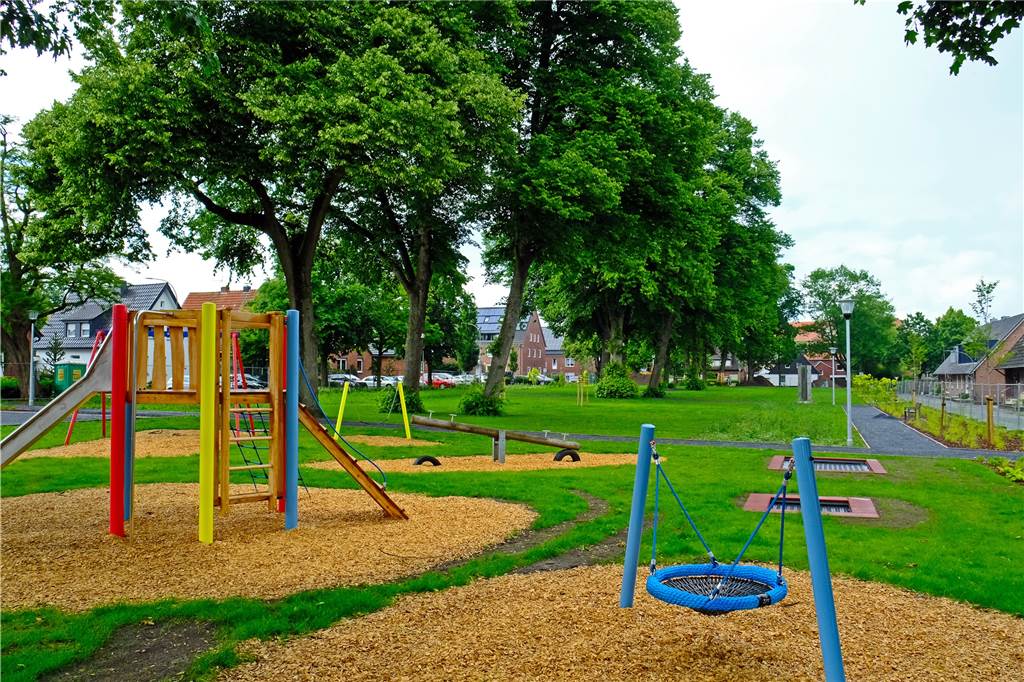 Die grüne Oase Owweringpark in Stadtlohn nimmt Gestalt an Spielplatz mit den beiden Bodentrampolinen, Nestschaukel und Rutschenturm. Im Hintergrund erkennt man die breiteren Wege mit den neuen Laternen.