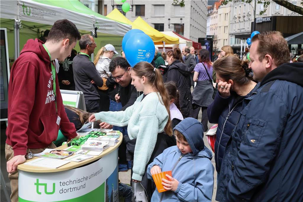 Menschen stehen an einem Stand.
