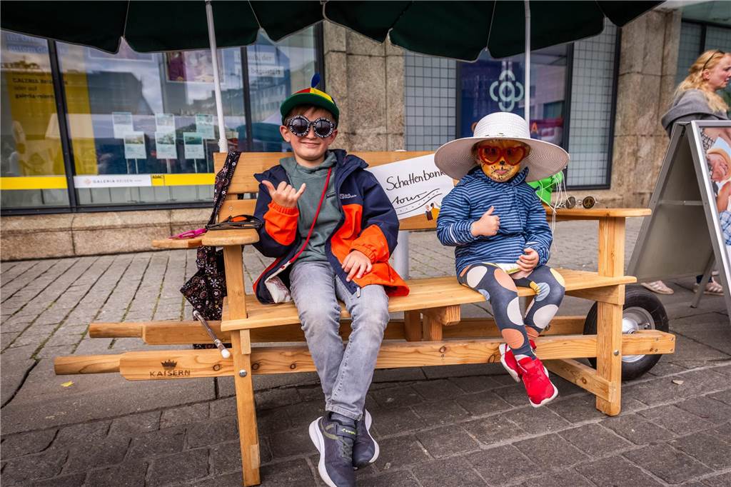 Zwei Kinder sitzen auf einer Bank.