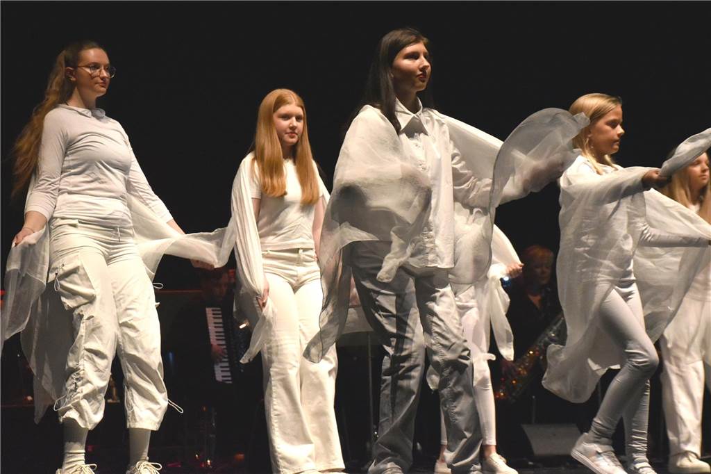 Christmas-Show: Musikschule begeistert das Publikum im Theater Mädchen in weißen Kostümen auf der Bühne