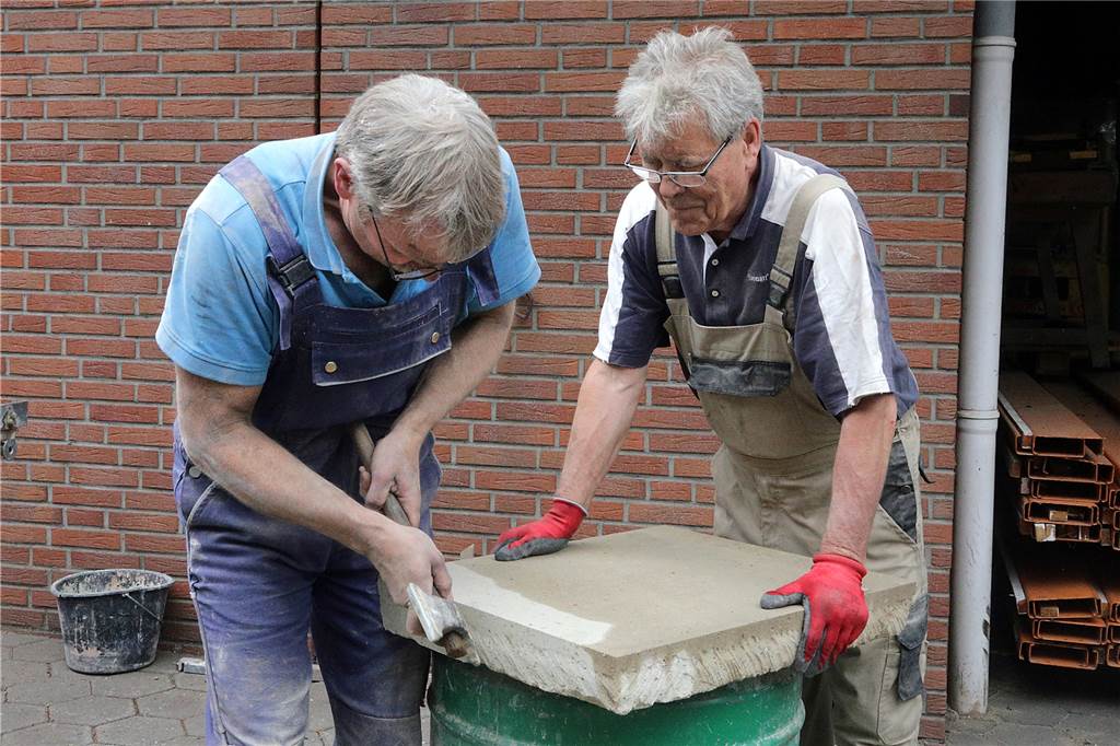 Neue Steine für historischen Backofen bei Balke: Handwerker geben alles Der Tuffstein wird vor dem Einsetzen in den Ofen von Claus Heuft und Rolf Golling vorbereitet.