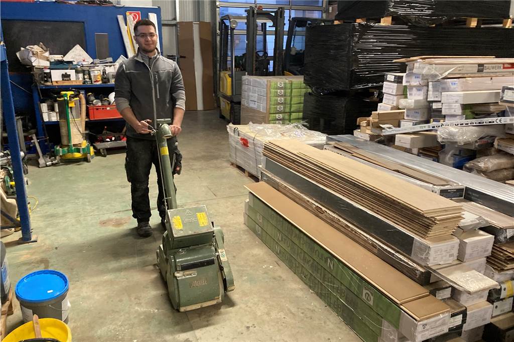 Erfolgsgeschichte: Mohamad (25) aus Syrien ist jetzt Geselle Mohamad mit der Schleifmaschine im Materiallager von Teppich Schwering